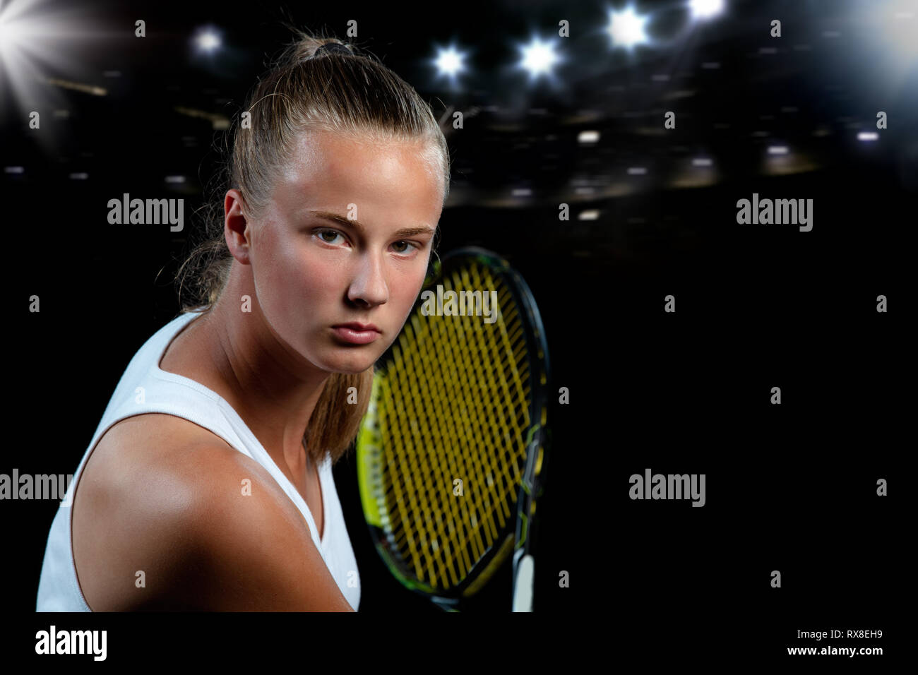 Beautiful girl tennis player with a racket on dark background with