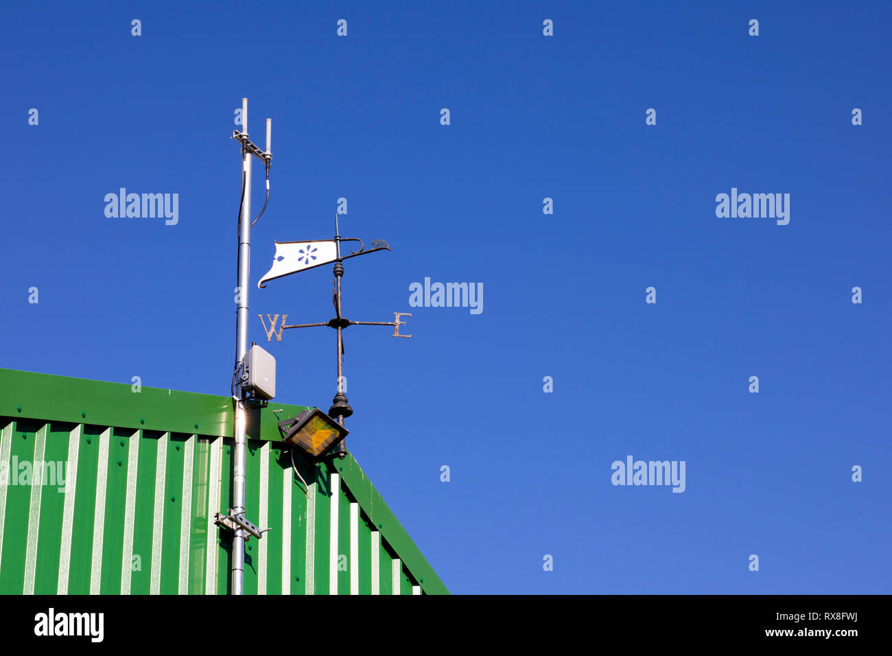 Metal weather vane fixed to top of building to show wind direction with