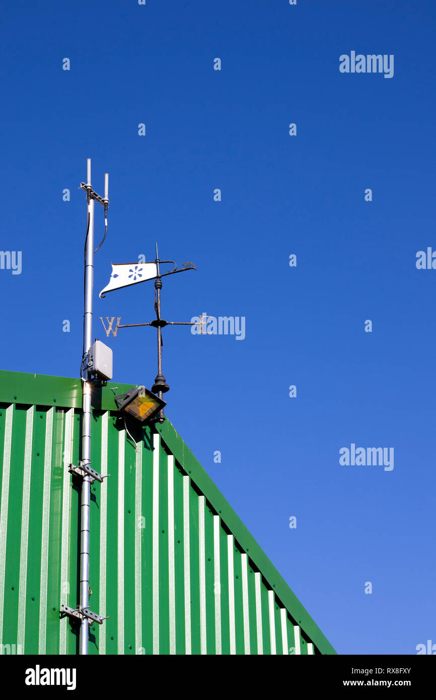 Metal weather vane fixed to top of building to show wind direction with