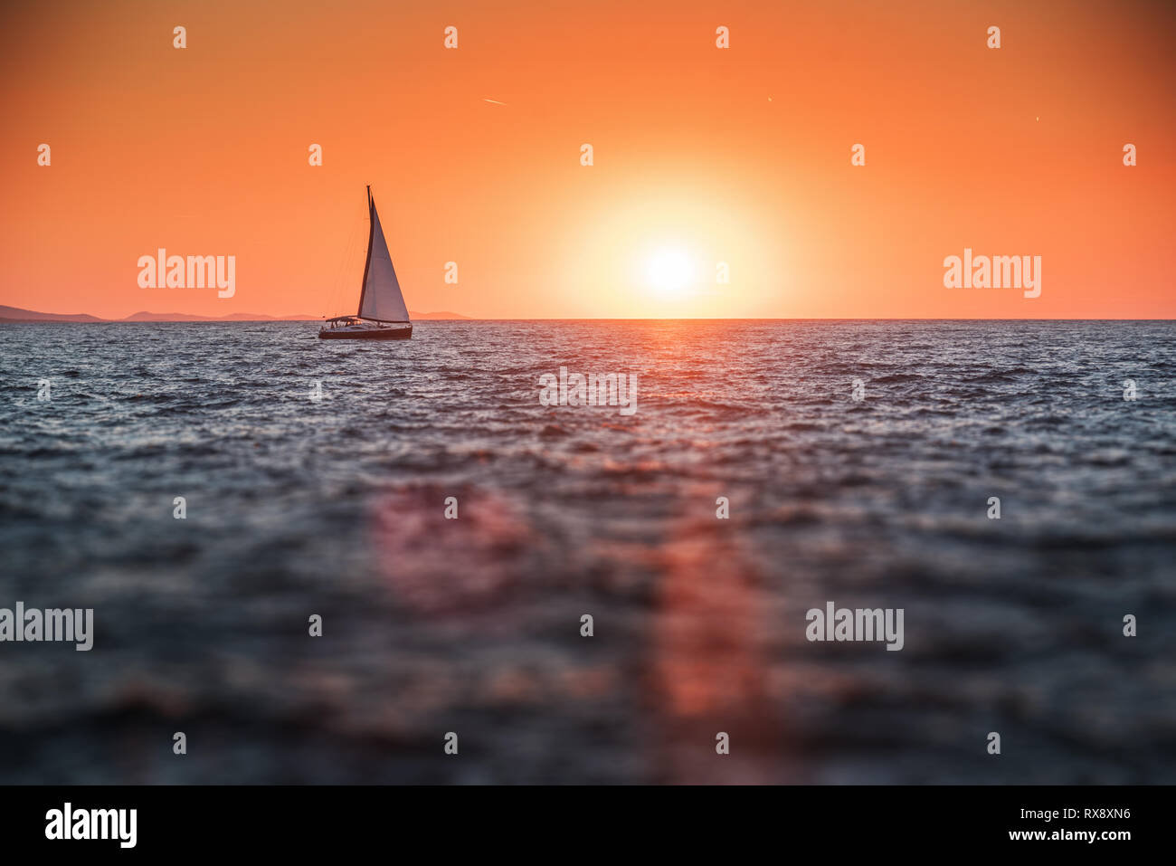 Sailing yacht in the sea at sunset Stock Photo - Alamy