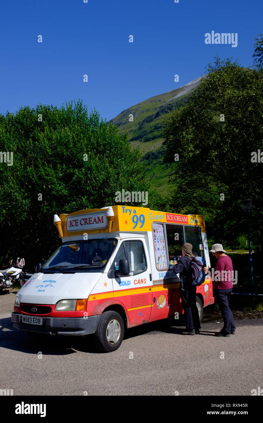 Customers being served ice cream from van during sunny summer weather