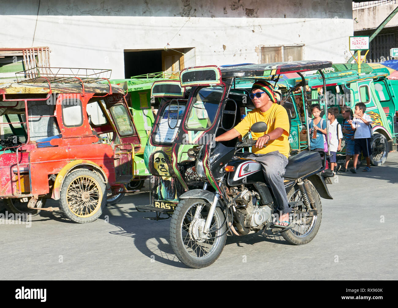 Romblon, Romblon Province, Philippines: Tricycle with Bob Marley design in the town center, parking tricycles in the background Stock Photo