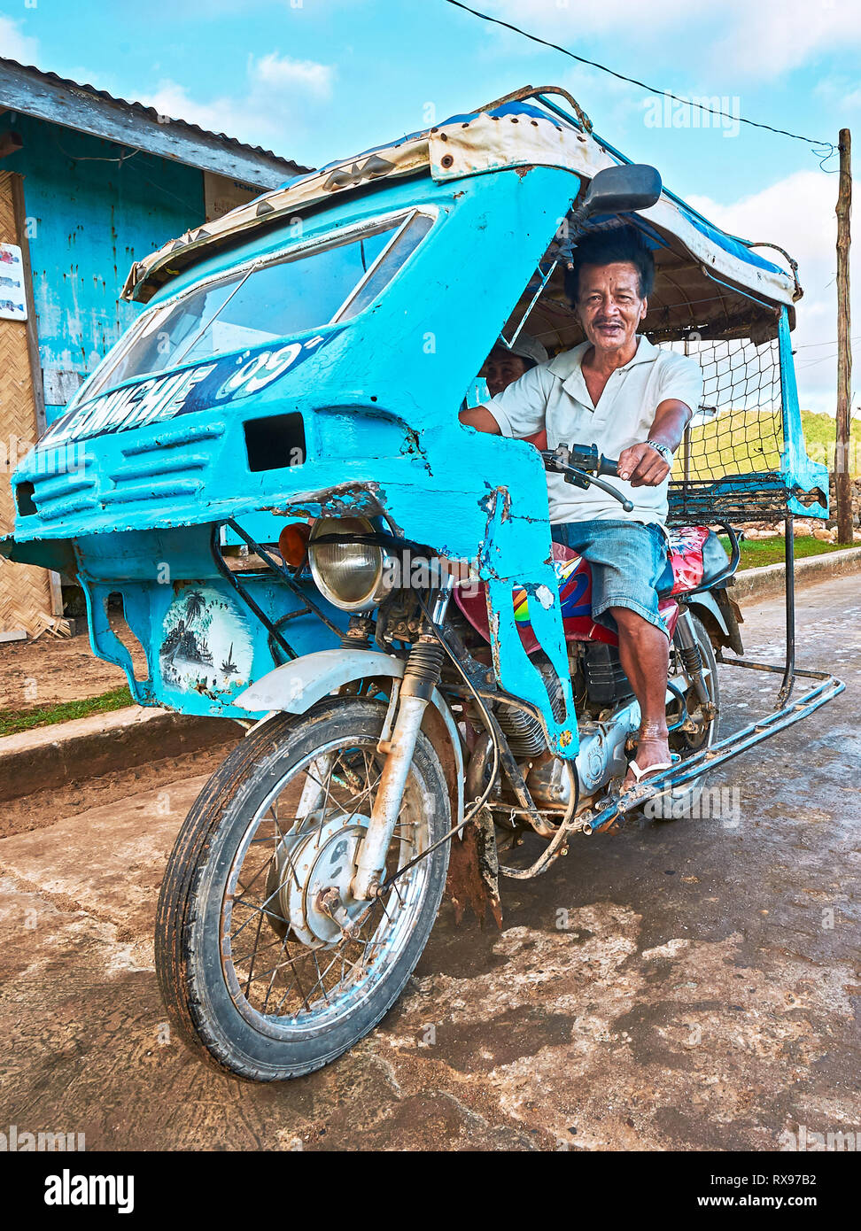 Taytay, Palawan Province, Philippines: Blue colored old tricycle with old age male driver near the wet market Stock Photo