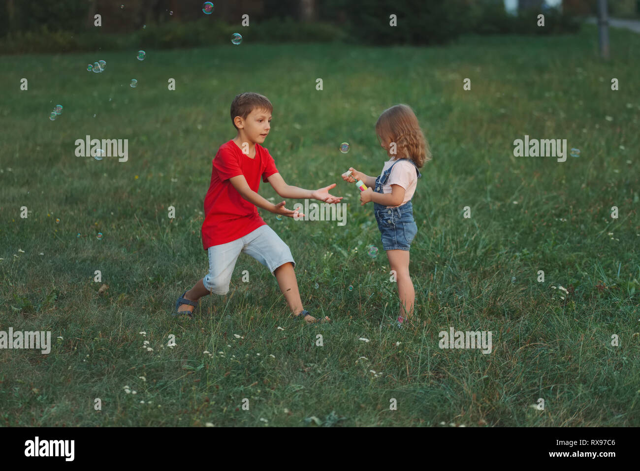 children playing with soap bubbles in park Stock Photo - Alamy