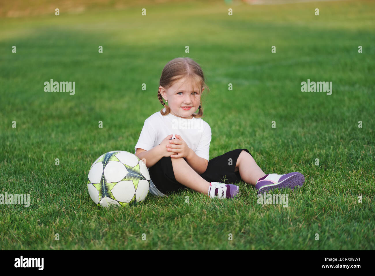 little happy girl on football field Stock Photo Alamy