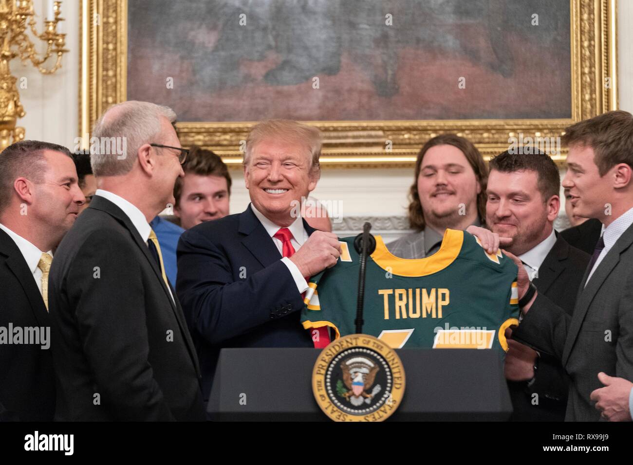 U.S President Donald Trump holds up a personalized college football jersey during a celebration with the 2018 FCS Division I Football National Champions the North Dakota Bisons in the State Dining Room of the White House March 4, 2019 in Washington, DC. Stock Photo