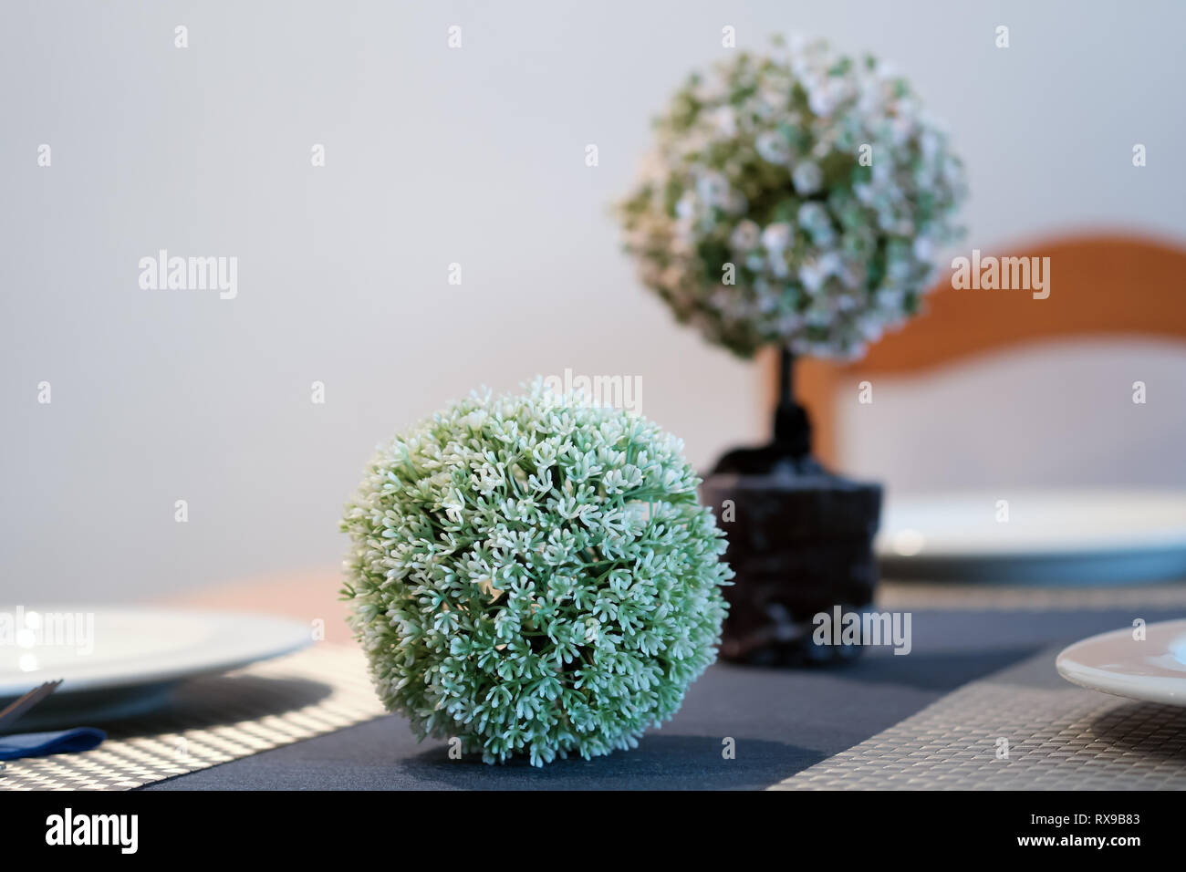 Home decoration artificial flowers green pink colours round shape close up indoors, no people, selective focus. Detail for cozy and comfortable atmosp Stock Photo
