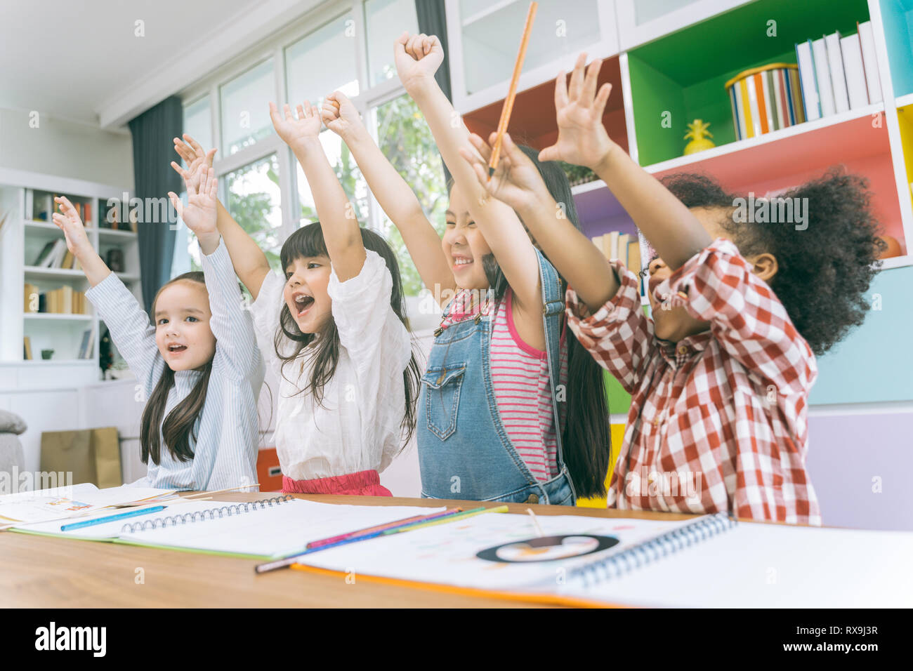 Group of little preschool kids hands up in class . portrait of children diversity education concept. Stock Photo