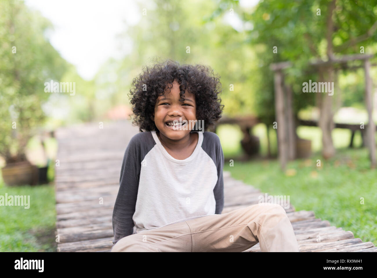 portrait of a cute African american little boy smiling at nature park. Stock Photo