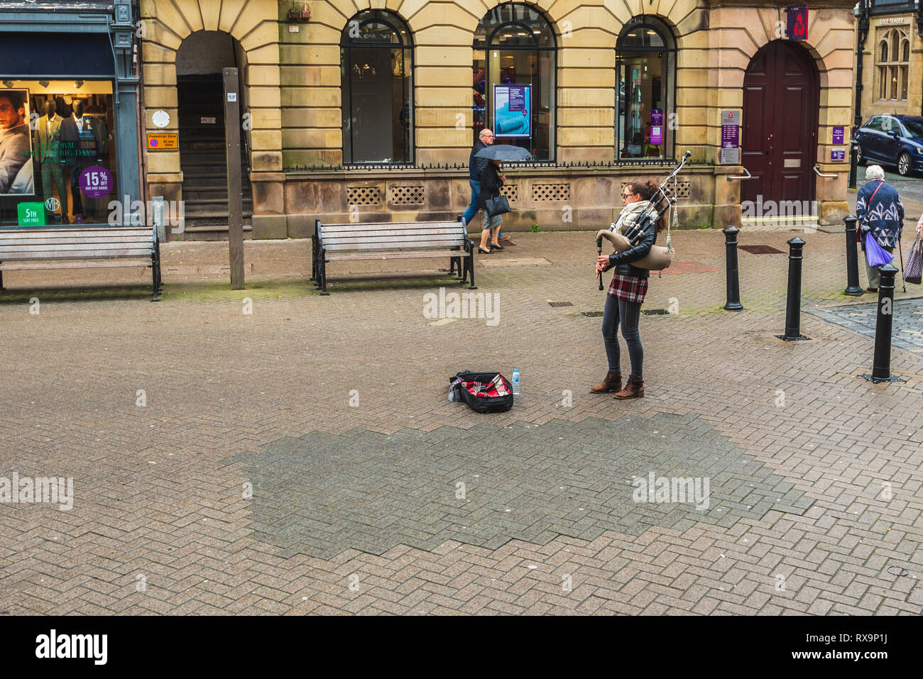 CHESTER, ENGLAND - MARCH 8TH, 2019: A female Bagpipe Busker plays in Chester Stock Photo