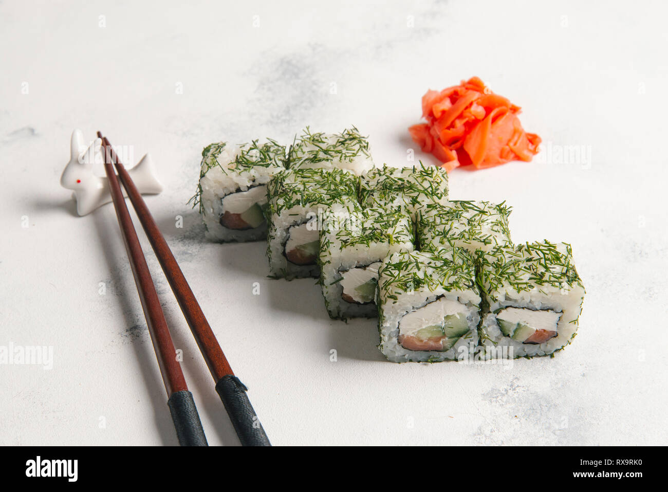 High angle view of sushi rolls with chopsticks and salmons served on table Stock Photo