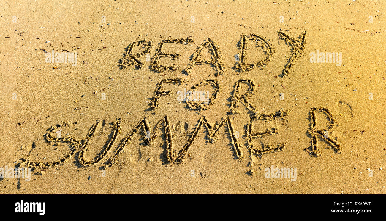 Hand written in sand ready for summer words top view - Writing in sand on beach under warm sunlight - Concept of getting ready for summer vacation Stock Photo