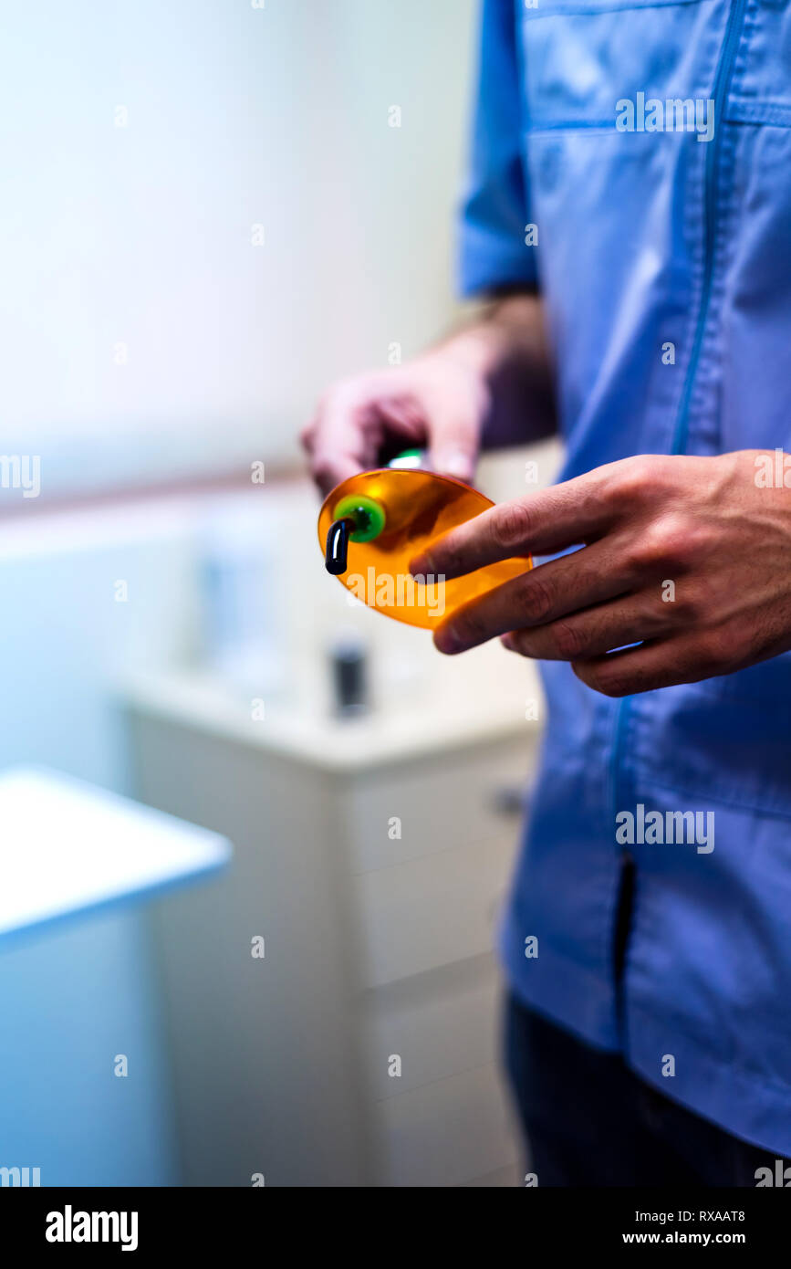 Dentist holding a dental curing lamp close up Stock Photo