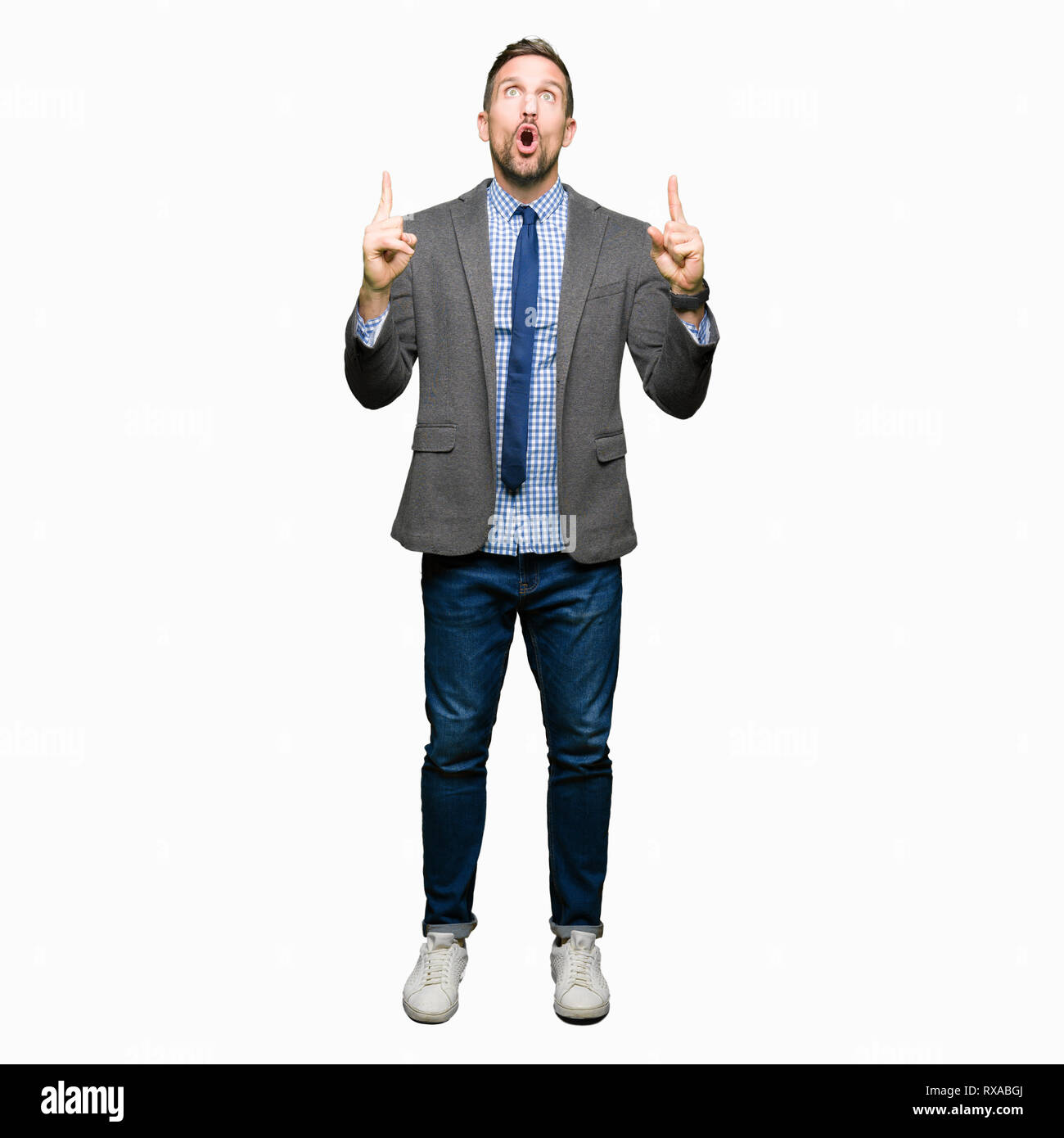 Handsome Business Man Wearing Suit And Tie Amazed And Surprised Looking Up And Pointing With Fingers And Raised Arms Stock Photo Alamy