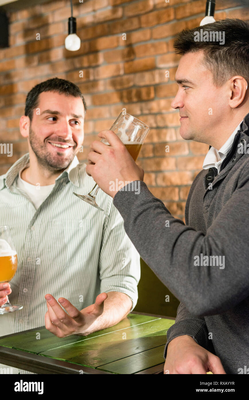 Friends drinking beer in a pub Stock Photo