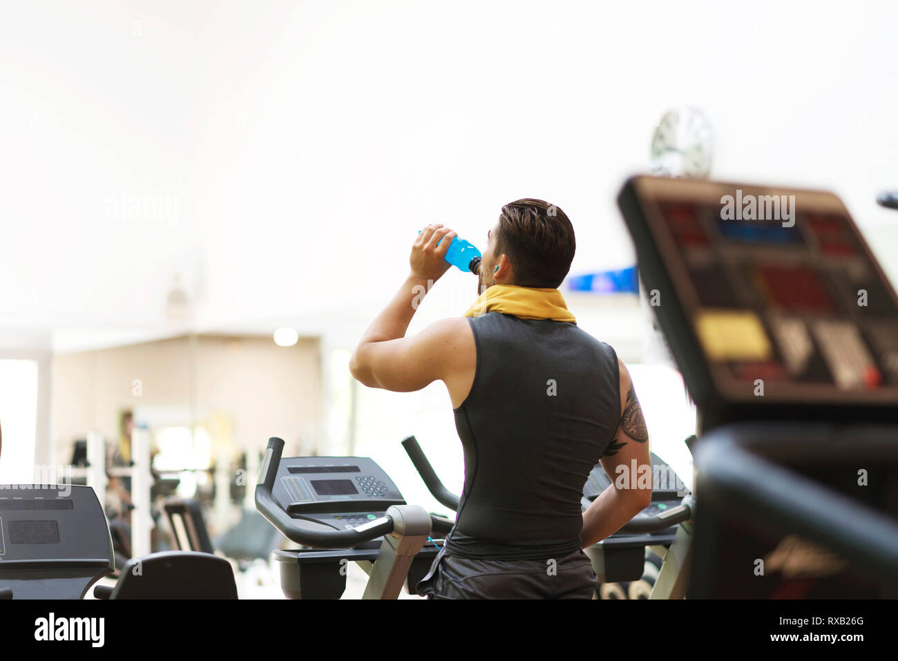 Rear view of man drinking water while exercising in gym Stock Photo Alamy