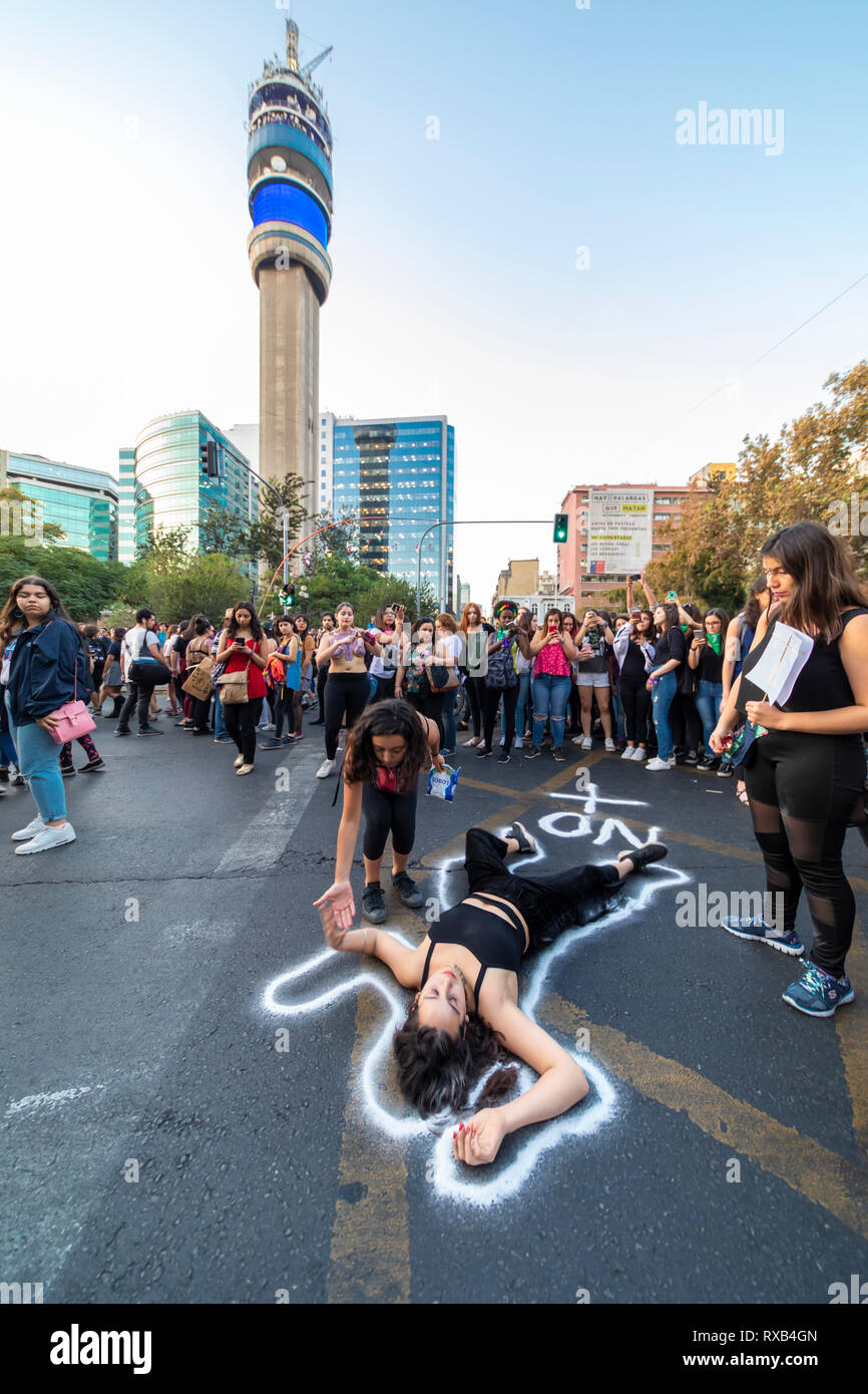 Girl protester lying on the street asphalt at International Women's Day 8 March at Santiago city centre streets, Chile Stock Photo
