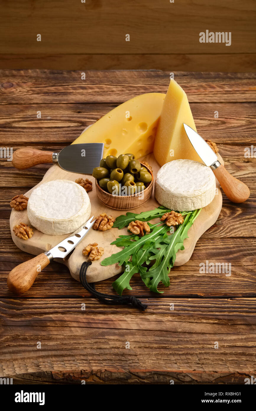 Different types of cheeses brie, camembert, parmesan and gouda on