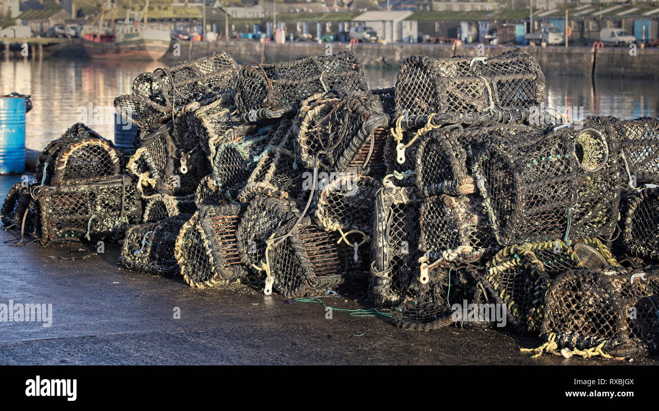 Lobster pots, piled high on Newlyn harbour quay, Cornwall, England, UK. Stock Photo