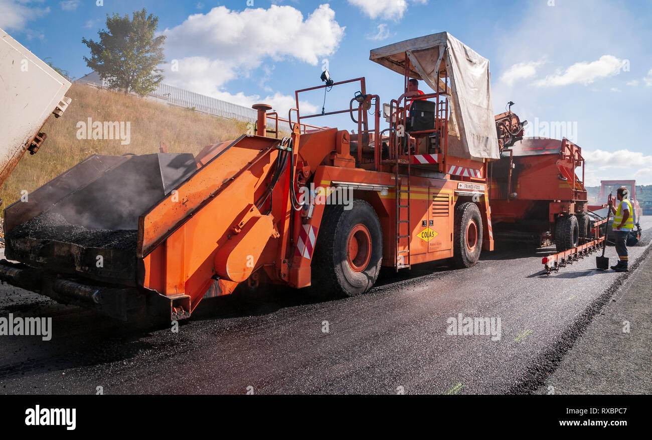 Asphalt Paving Train. In the foreground, the vehicle transferring the