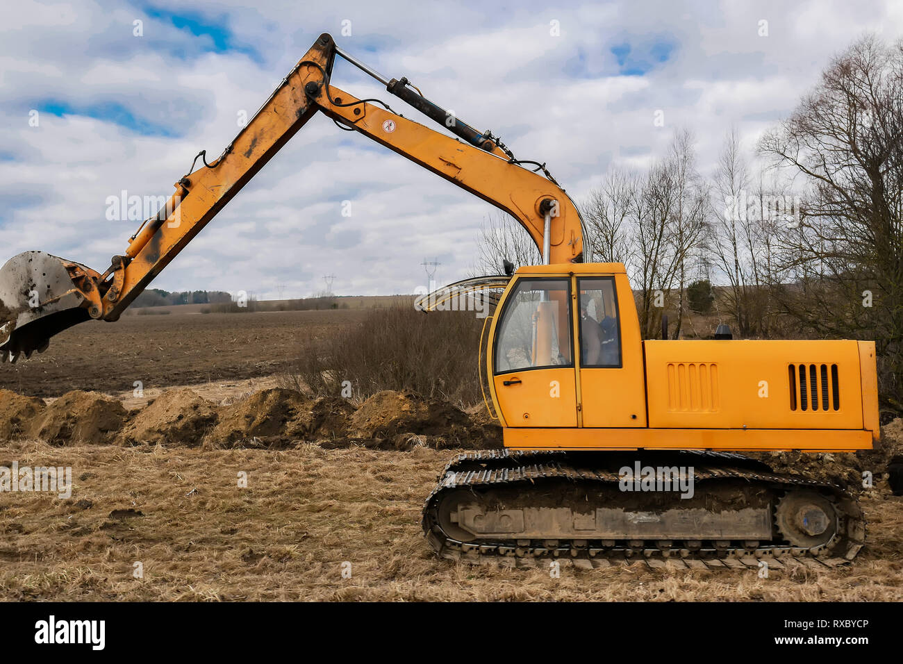 yellow excavator digging the ground Stock Photo - Alamy