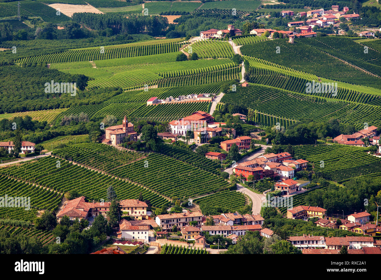 Small town among green vineyards on the hills in Piedmont, Northern Italy. Stock Photo