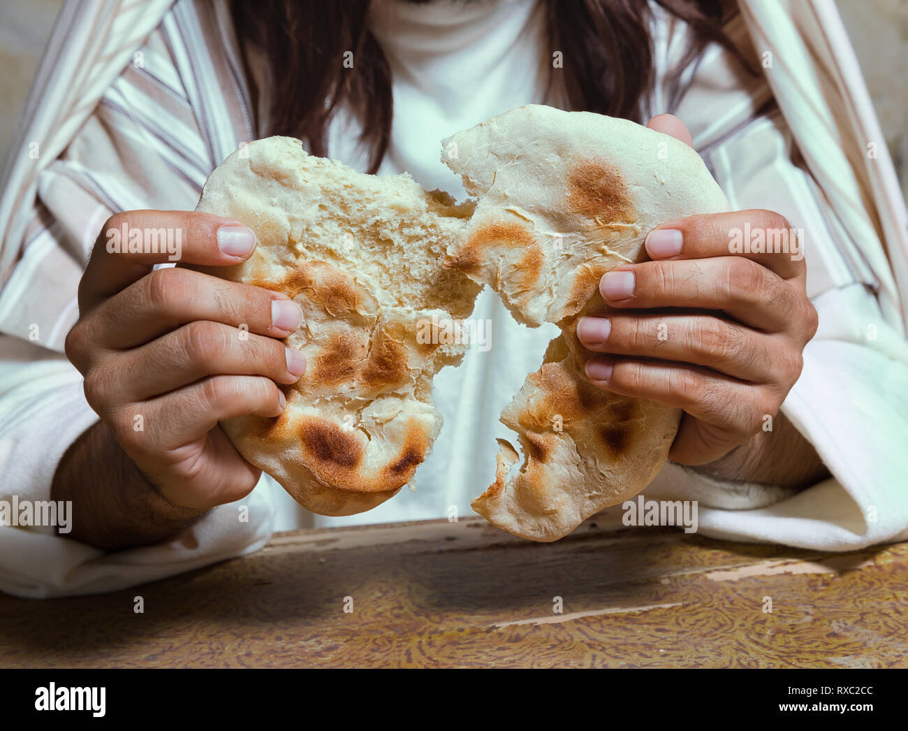 Authentic reenactment scene of Jesus breaking the bread during Last Supper, saying 'this is my body'. Stock Photo
