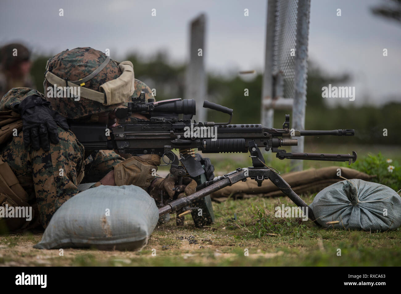 A Marine with Combat Logistics Battalion 31 fires an M249 Squad Automatic Weapon during machine gun and heavy-weapons training at Camp Hansen, Okinawa, Japan, March 7, 2019. During the training, the CLB-31 Marines learned the fundamentals to act as safety officers for upcoming unit-wide training.  CLB-31 is the Logistics Combat Element for the 31st Marine Expeditionary Unit. The 31st MEU, the Marine Corps’ only continuously forward-deployed MEU, provides a flexible and lethal force ready to perform a wide range of military operations as the premier crisis response force in the Indo-Pacific Reg Stock Photo
