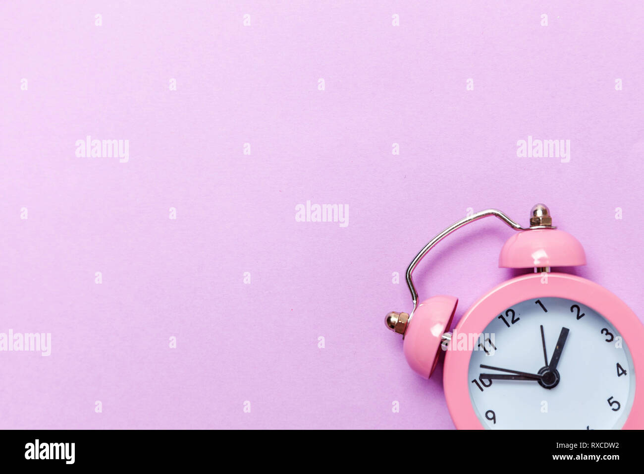 Ringing twin bell vintage classic alarm clock Isolated on purple violet pastel colourful