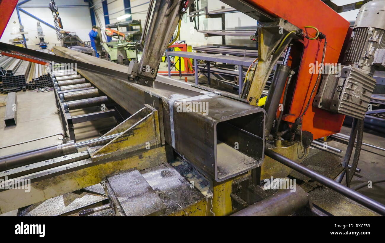 A big metal saw cutting one side of the metal. Using a big machine to cut a big  metal parts Stock Photo - Alamy
