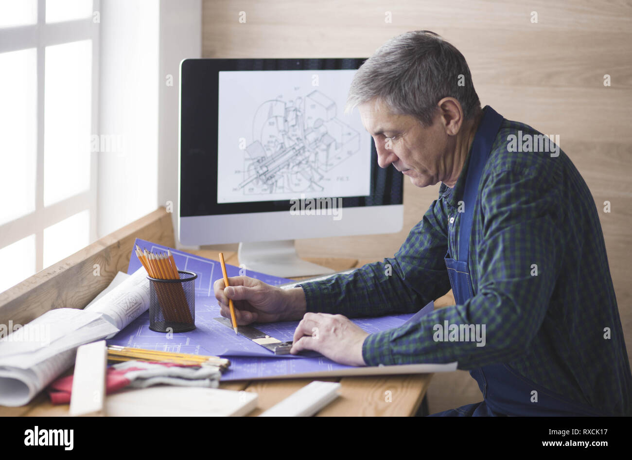Engineer carpenter working on laptop and sketching project Stock Photo ...