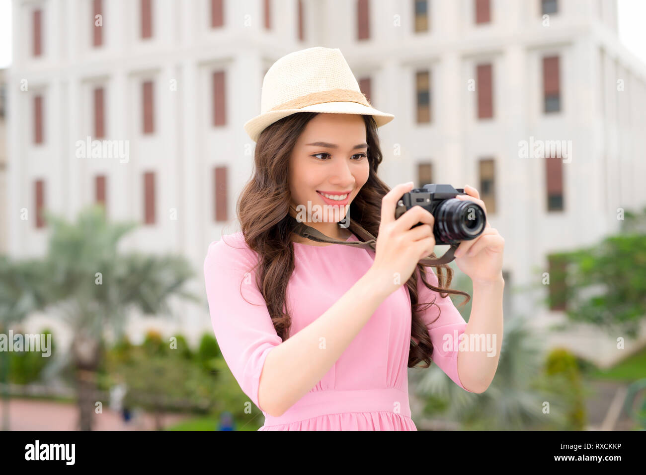 Outdoor summer smiling lifestyle portrait of pretty young woman having fun in the city in Asian with camera travel photo of photographer Stock Photo