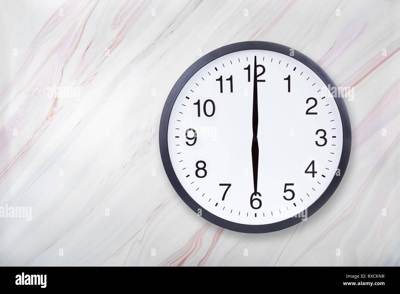 Wall clock show six o'clock on marble texture. Office clock show 6pm or 6am Stock Photo