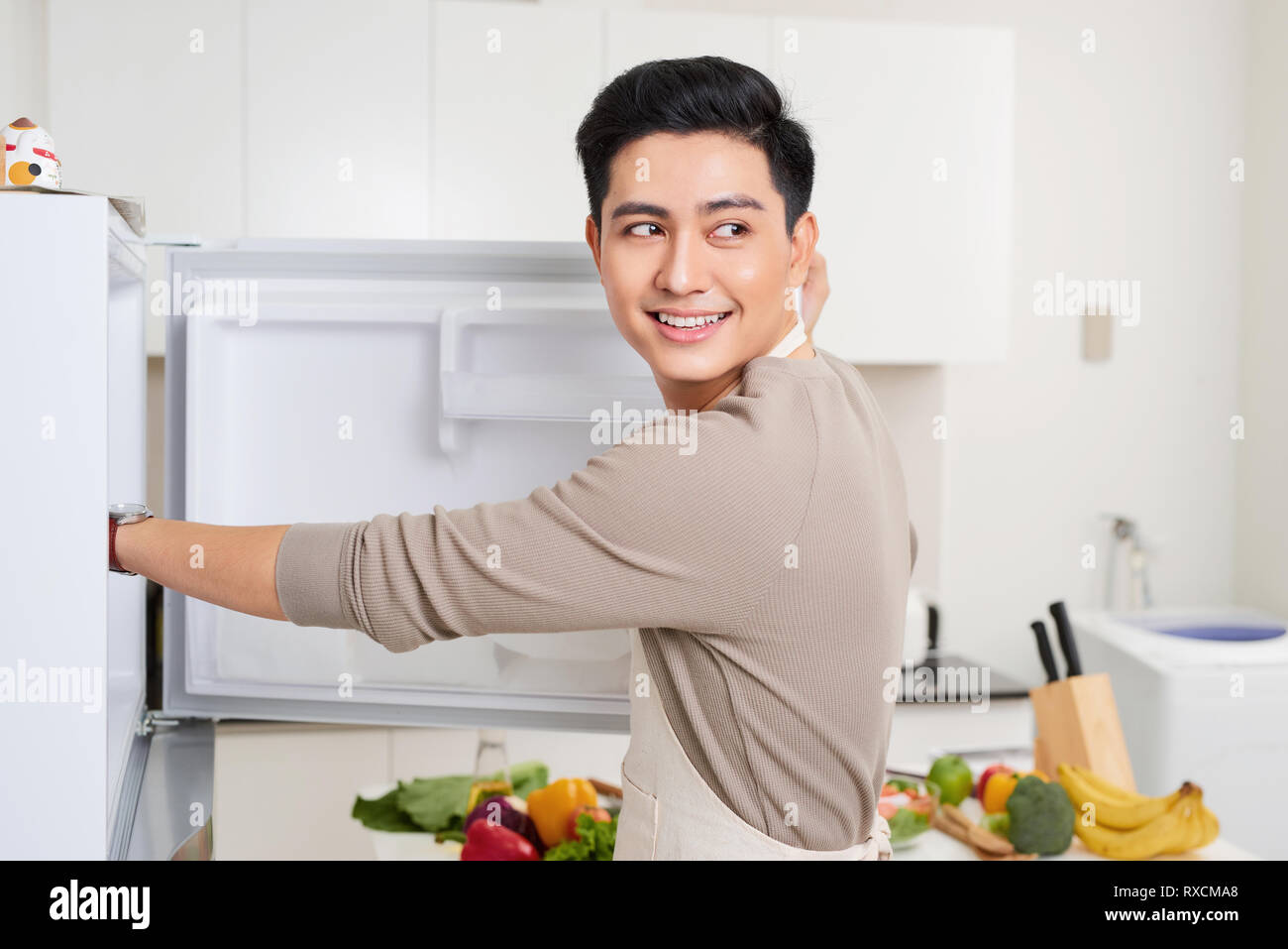 Abstract hand a young man is opening a refrigerator door Stock Photo