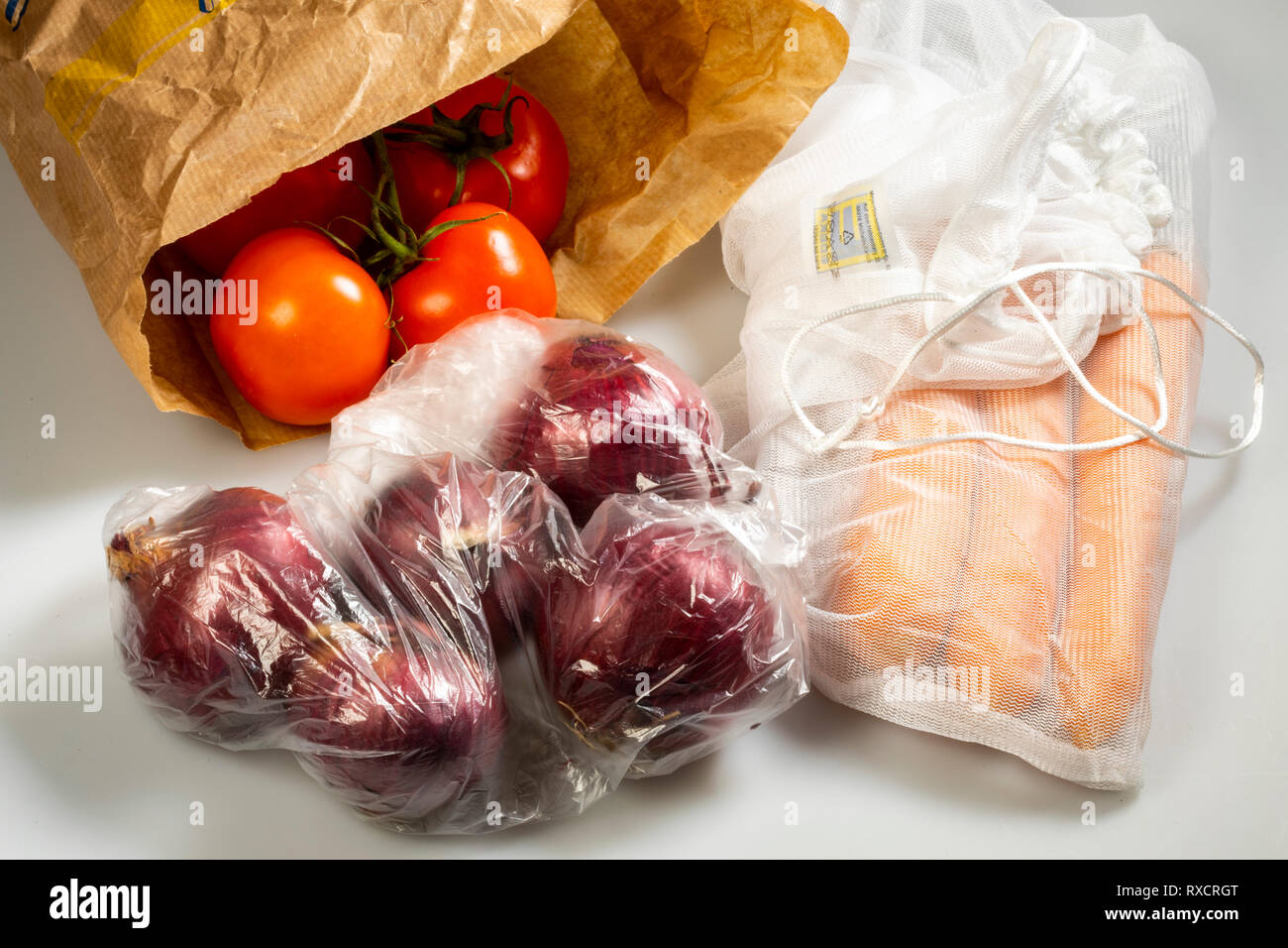 https://c8.alamy.com/comp/RXCRGT/food-packaging-carrots-in-a-reusable-plastic-net-avoiding-plastic-garbage-onions-in-a-disposable-plastic-bag-tomatoes-in-a-paper-bag-RXCRGT.jpg