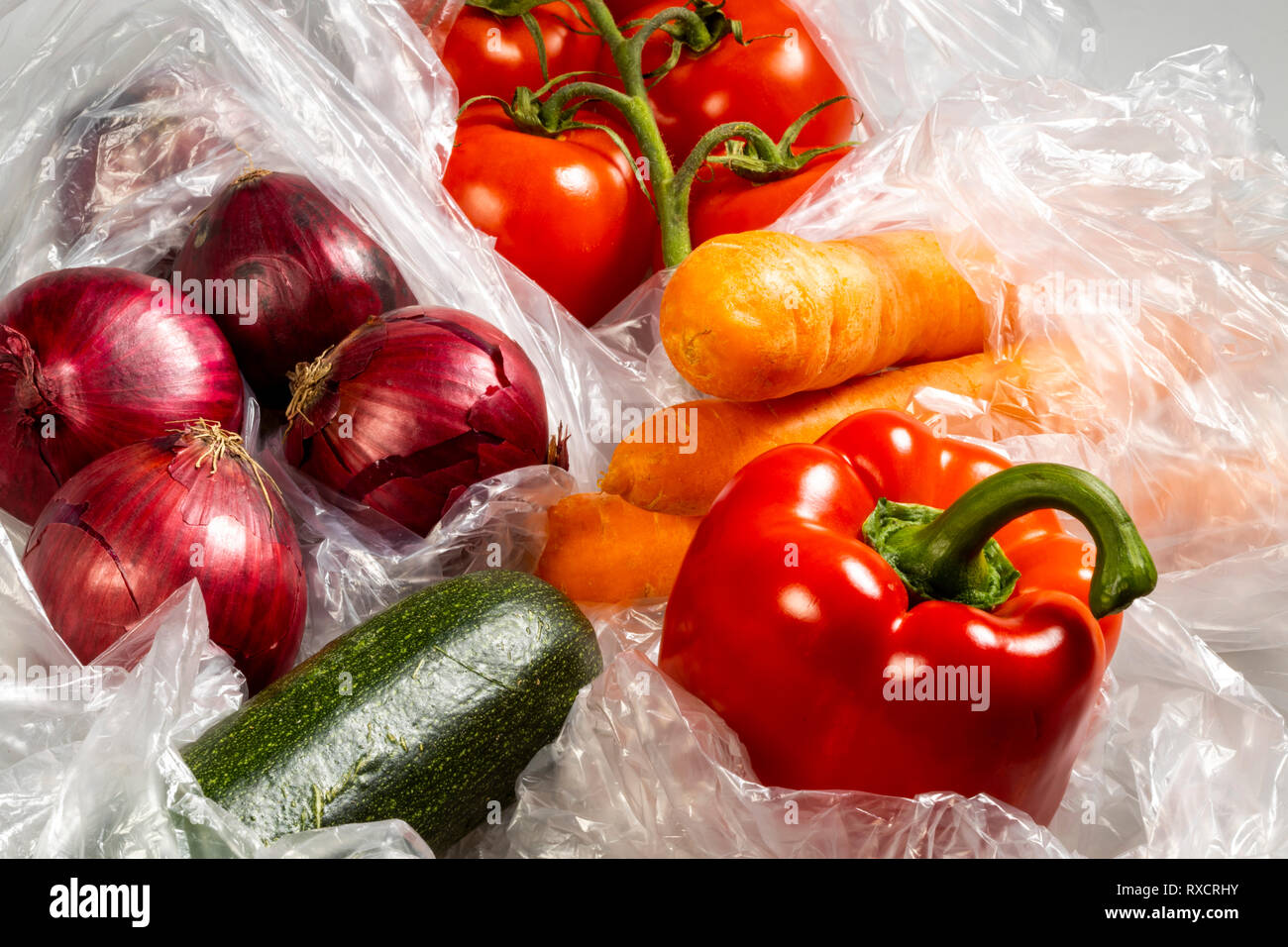 Food packaging, disposable plastic bags, vegetables, peppers, tomatoes, carrots, onions, from the supermarket, Stock Photo