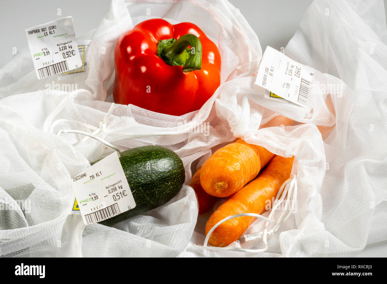 Lebensmittel Verpackungen, Paprika, Möhren, Zucchini in einem wiederverwendbaren Kunststoffnetz, zur Vermeidung von Plastikmüll, Preisetikett, Stock Photo