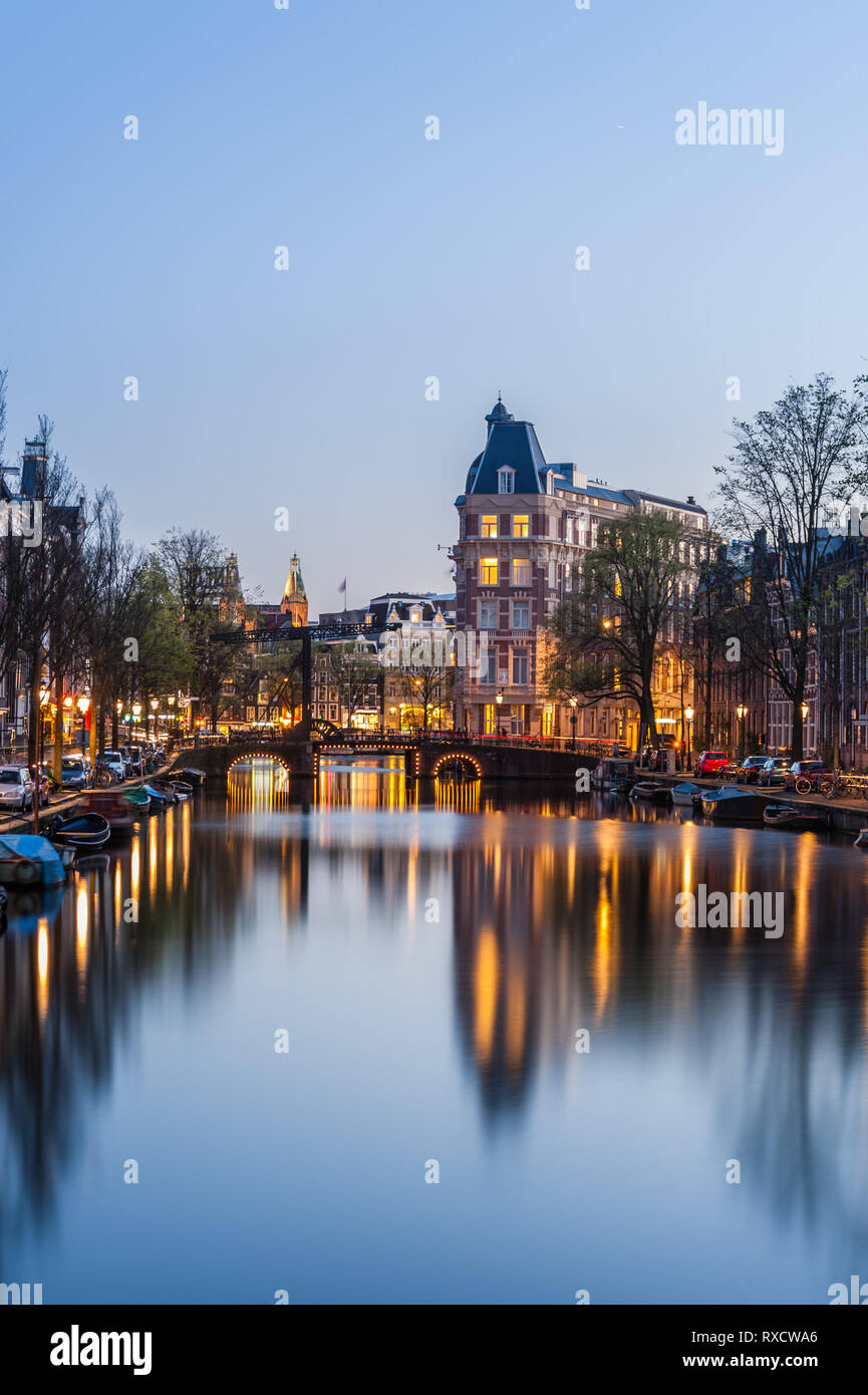 Evening landscape with houses and canal in Amsterdam, twilight and reflection in water, cityscape Stock Photo
