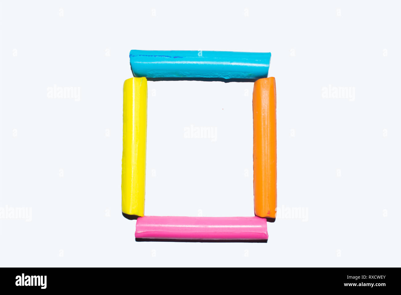Colorful clay sticks forming a square shape on a white background Stock Photo