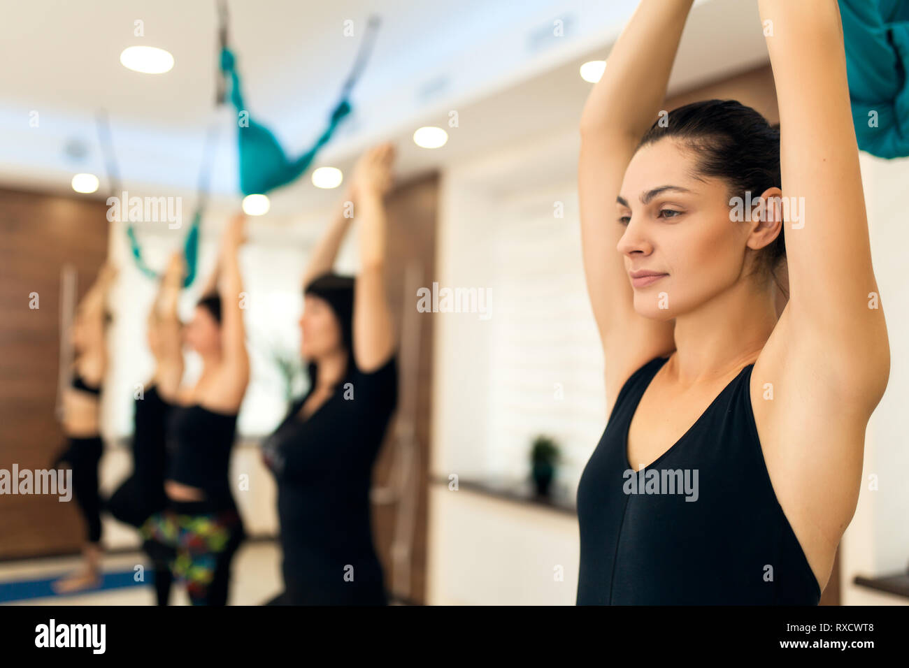 group of womans doing yoga exercises in gym. Fit and wellness lifestyle. Stock Photo