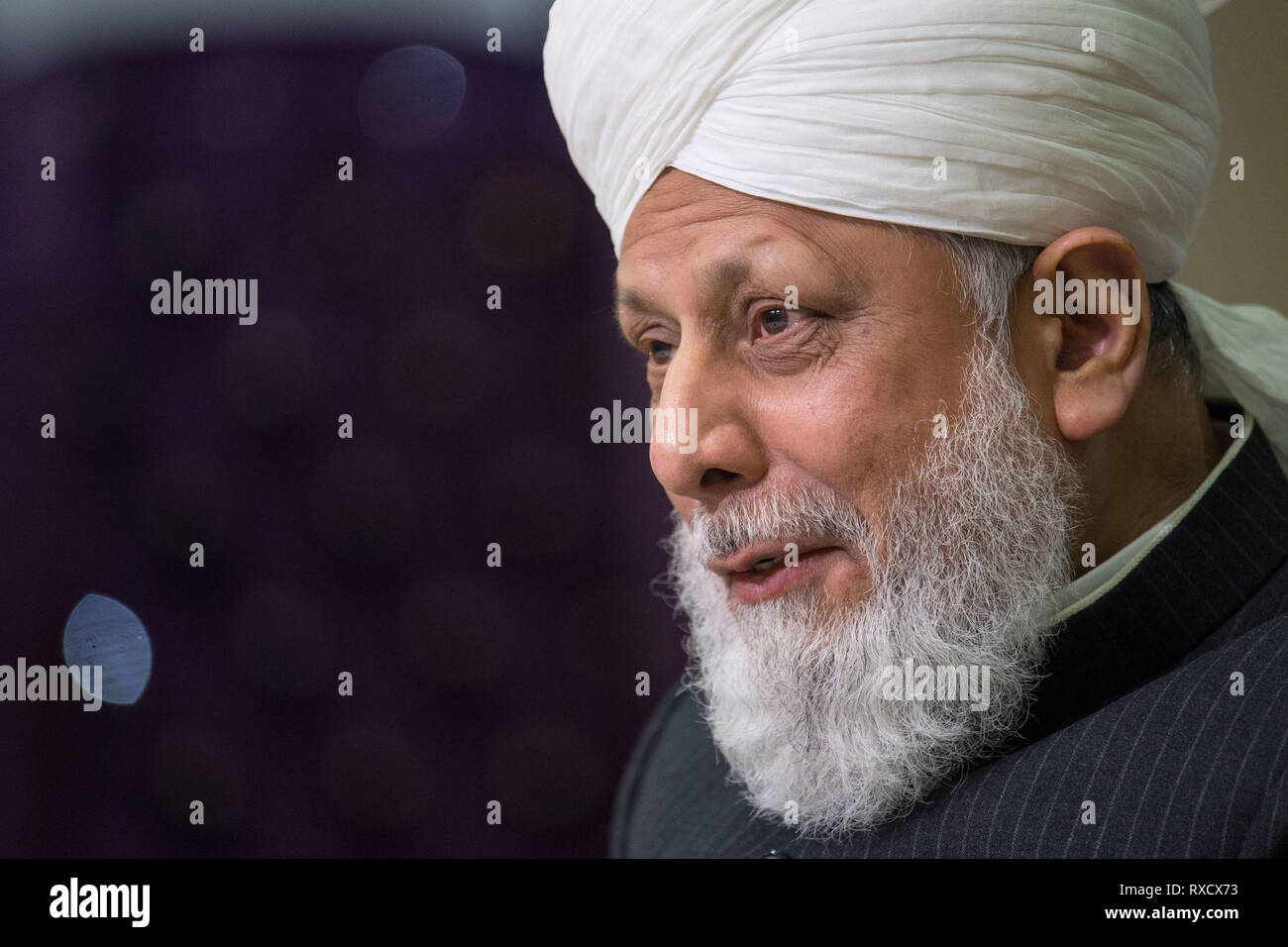 His Holiness Hazrat Mirza Masroor Ahmad speaks at a press conference during the National Peace Symposium, at the Baitul Futuh Mosque, in Morden, London. Stock Photo