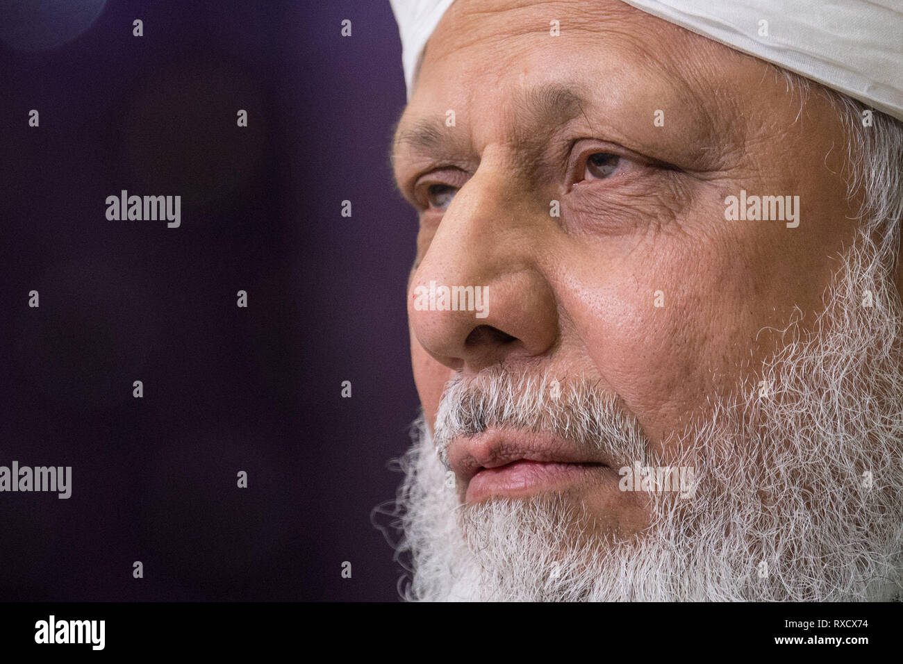 His Holiness Hazrat Mirza Masroor Ahmad speaks at a press conference during the National Peace Symposium, at the Baitul Futuh Mosque, in Morden, London. Stock Photo