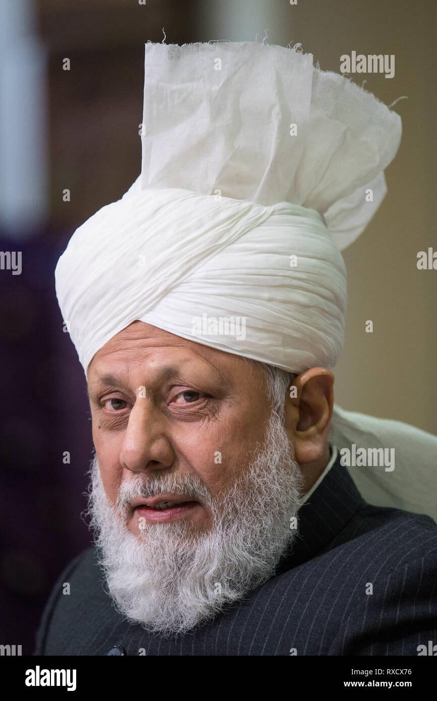 His Holiness Hazrat Mirza Masroor Ahmad speaks at a press conference during the National Peace Symposium, at the Baitul Futuh Mosque, in Morden, London. Stock Photo