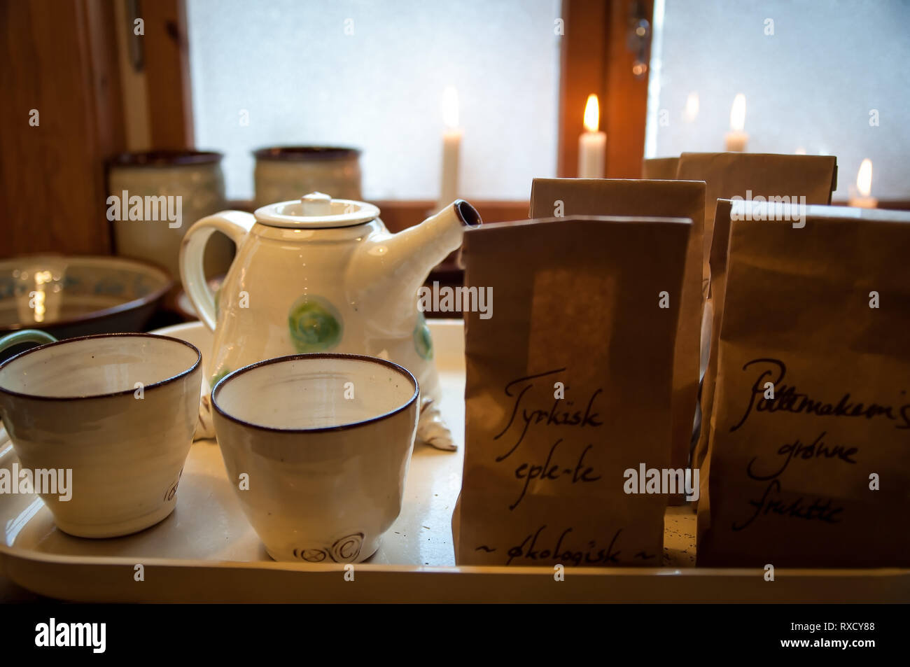 Cozy serving tray with ceramic teacups, teapot, brown paper tea bags