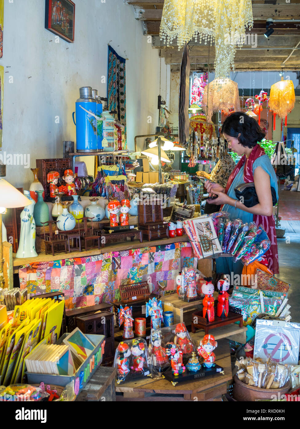 A tourist shopping for curios inside the shop 14 Living Story on Armenian Street, Penang. Stock Photo