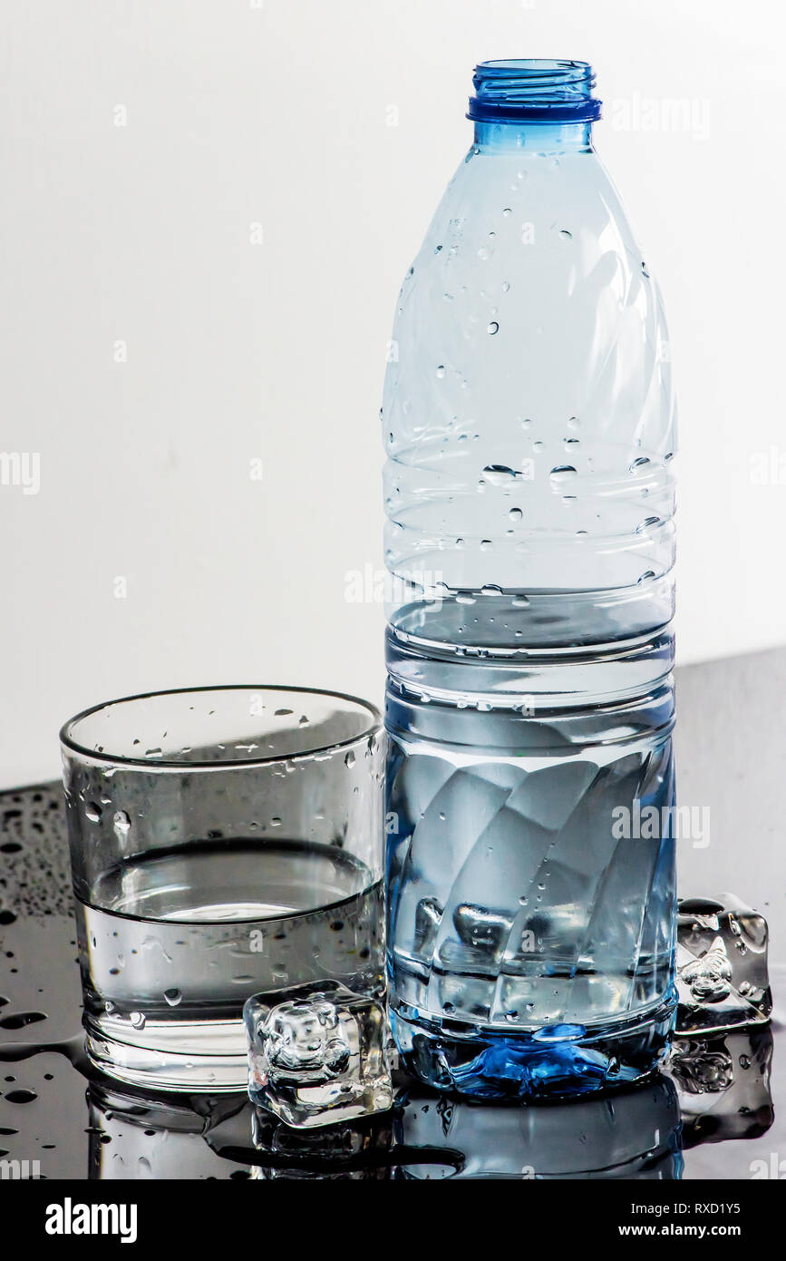 Sweaty Chilled Bottled water, ice cubes and glass Stock Photo Alamy
