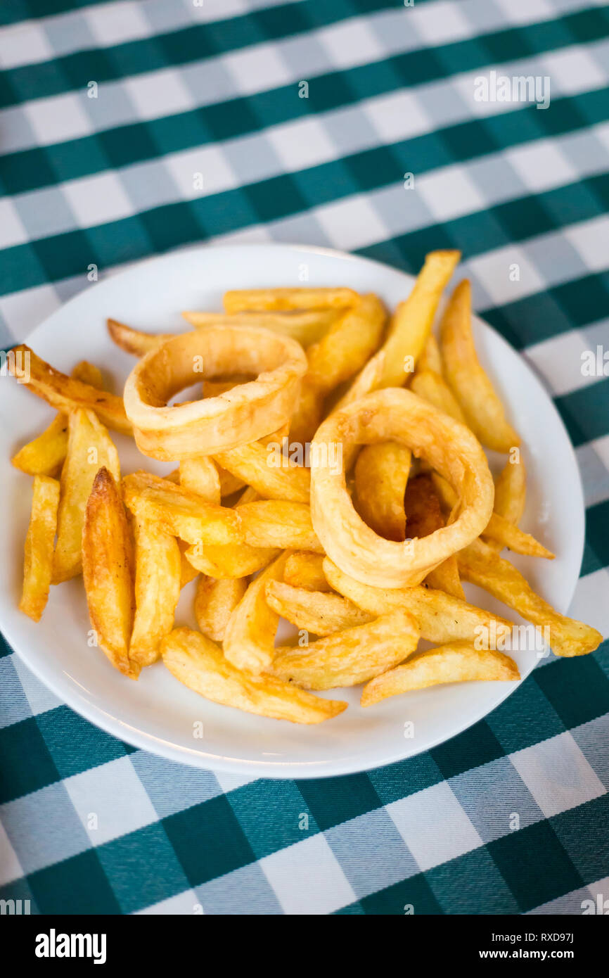 Deep fried squid with potato chips in local restaurant in Larnaca. Traditional cypriot meze food on Cyprus island. Stock Photo