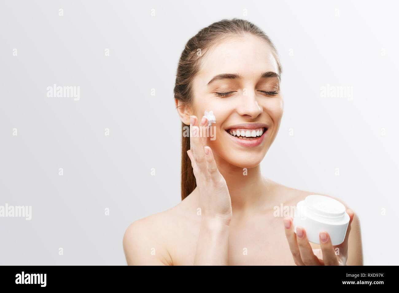 Woman applying facial cream on her face Stock Photo Alamy