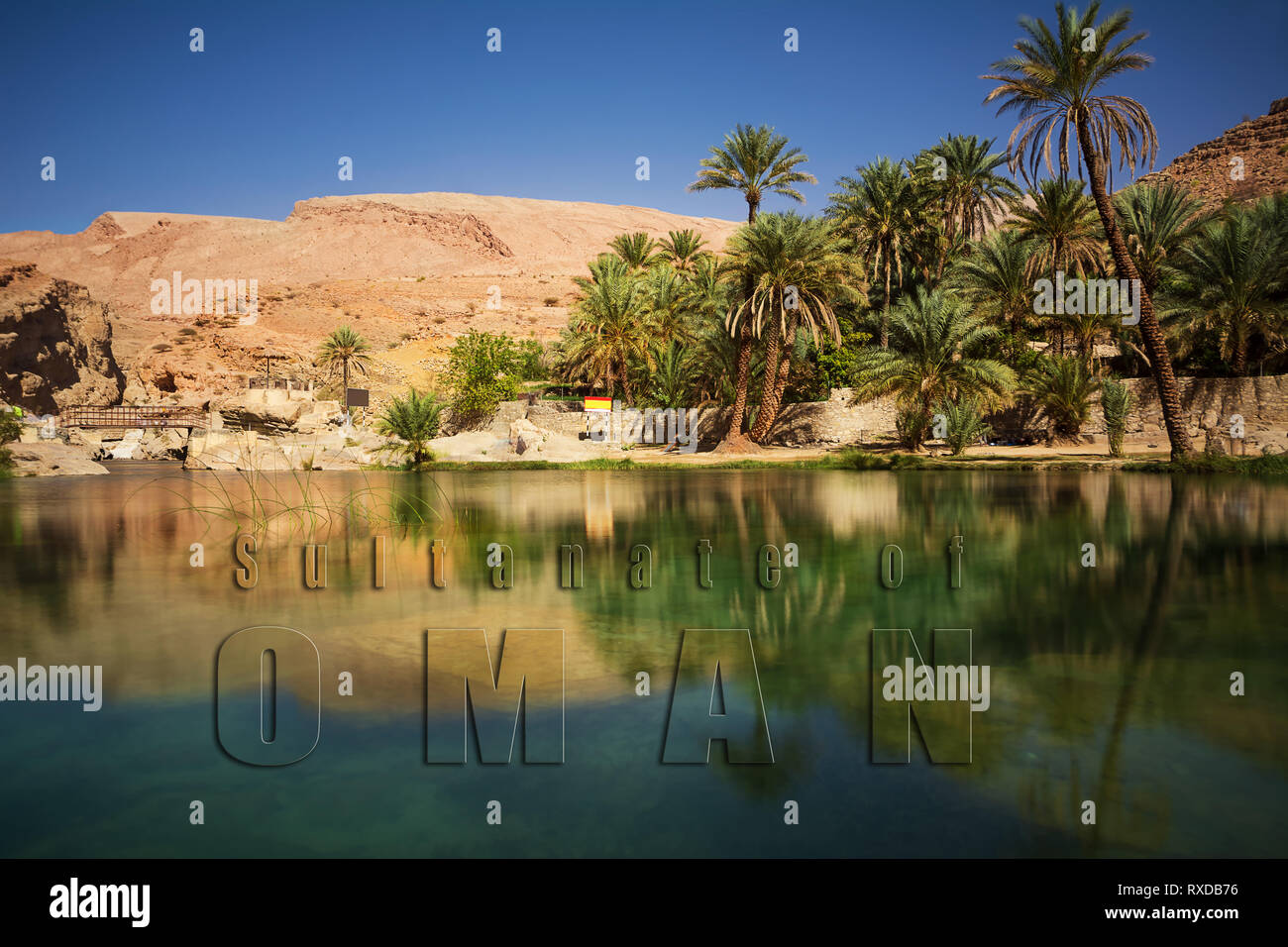 Wonderful lake and oasis with palm trees (Wadi Bani Khalid) in the Omani desert and overwritten text Stock Photo