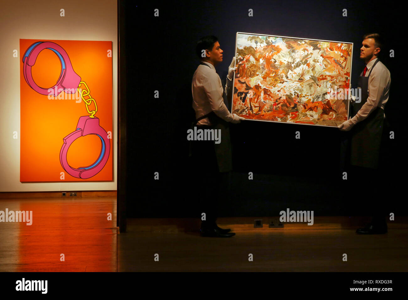 London Uk 8th Mar 19 Christie S Employees Pose With Artwork Previously Owned By Singer Songwriter George Michael Yet To Be Titled By Artist Cecily Brown Right And And Handcuffs By Michael Craig Martin Left